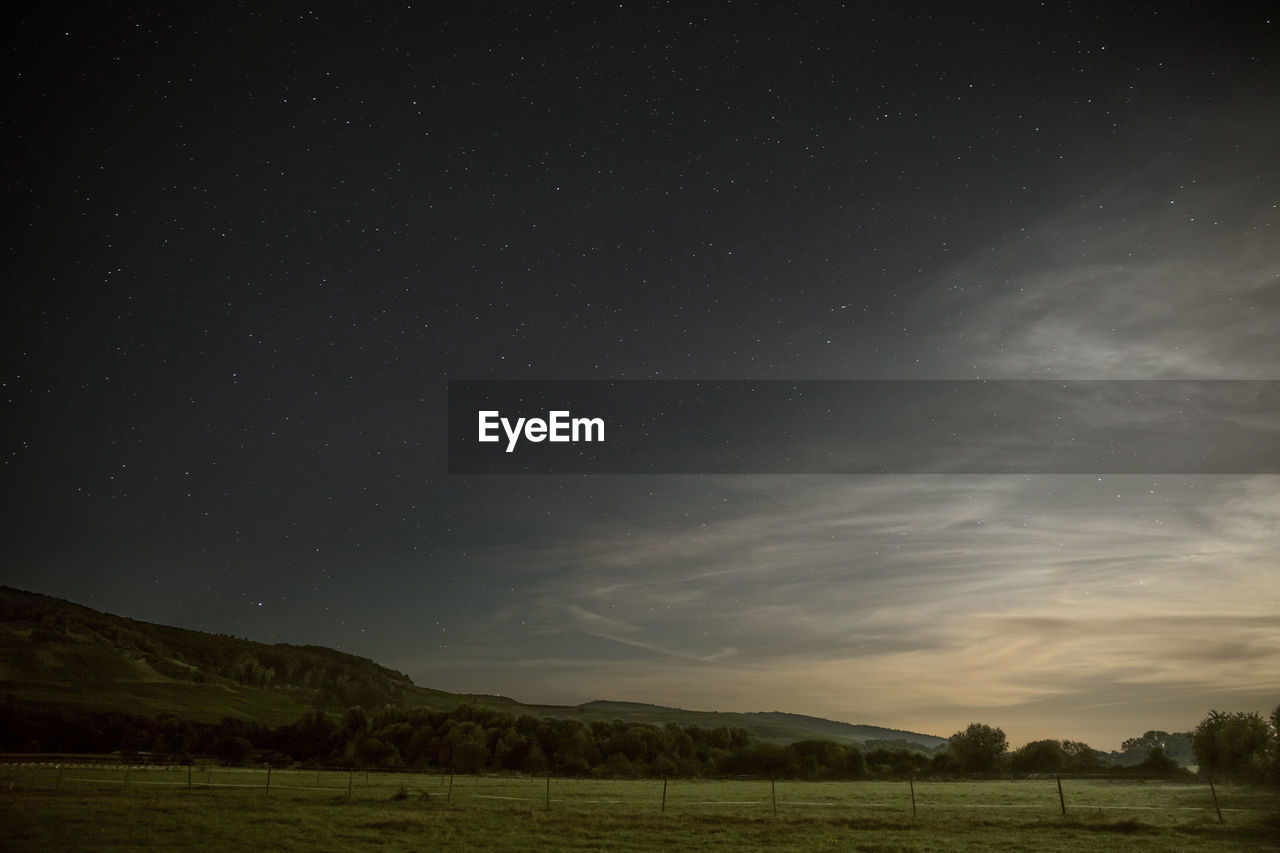 Scenic view of field against sky at night