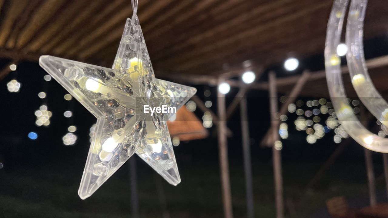 decoration, hanging, christmas decoration, star shape, celebration, christmas, holiday, no people, lighting, illuminated, lighting equipment, shape, focus on foreground, indoors, close-up, christmas ornament, light, event, tradition, shiny, night