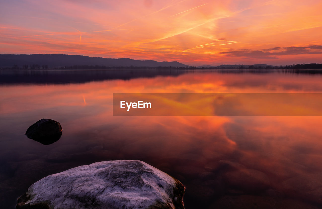 Scenic view of lake against sky during sunset