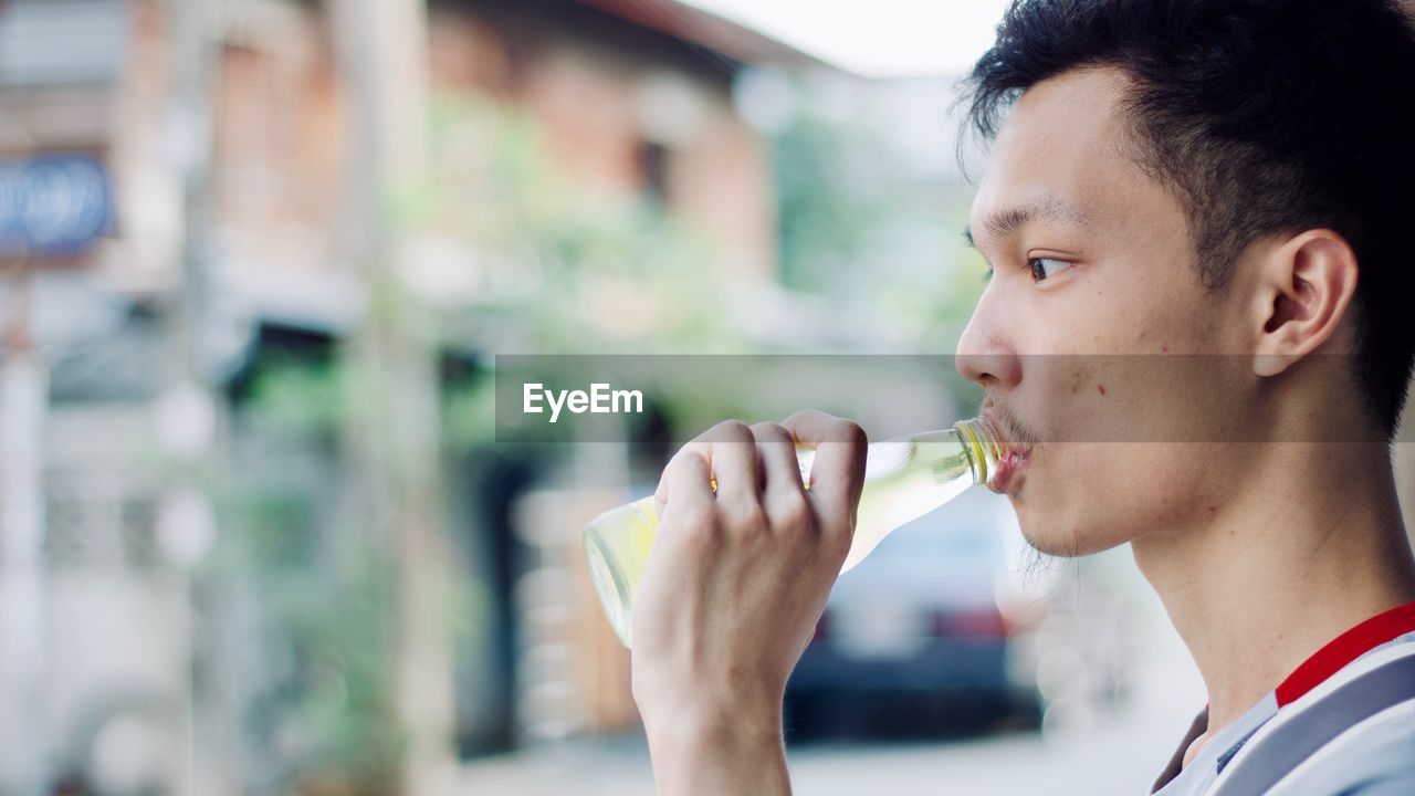 Close-up of young man having drink