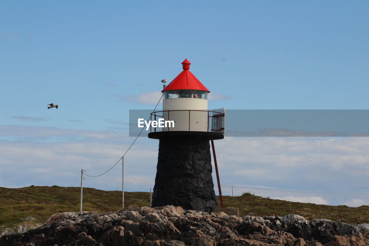 LIGHTHOUSE AGAINST SKY AND ROCK