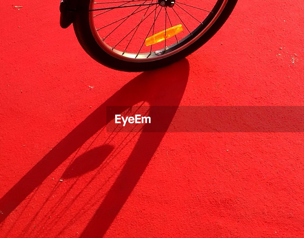 Close-up of bicycle on red wall