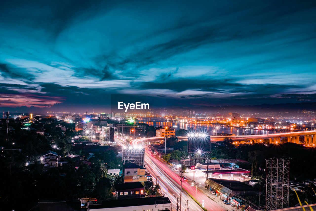 Illuminated cityscape against sky at night