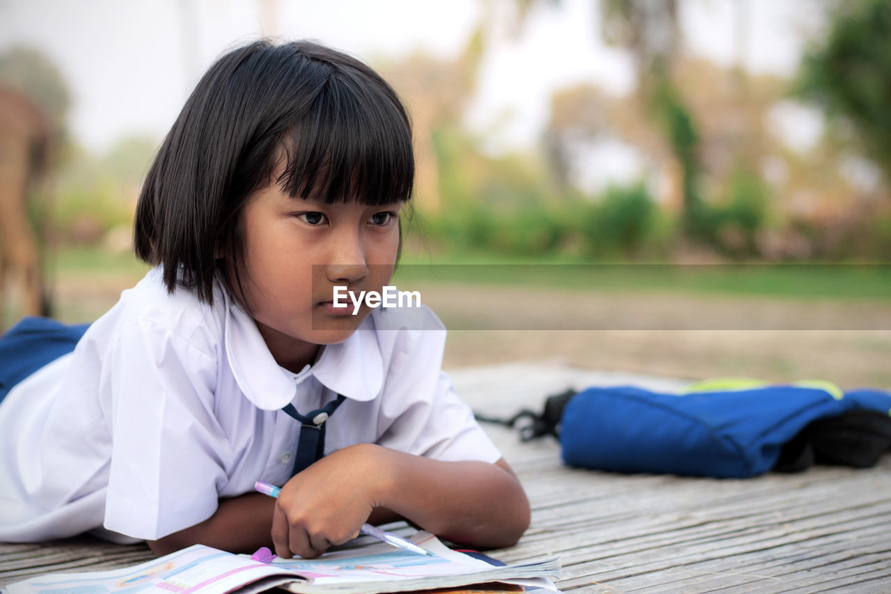 Thoughtful girls with books lying on wooden table