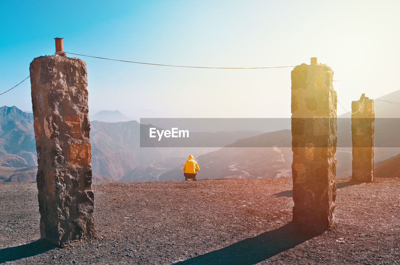 Rear view of person on mountain against sky