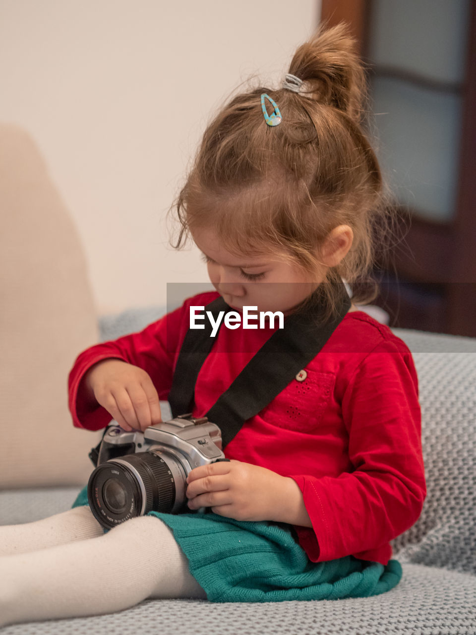 childhood, child, one person, baby, toddler, person, sitting, indoors, skin, female, women, looking, lifestyles, home interior, innocence, cute, holding, front view, casual clothing, concentration, full length, looking down, learning, portrait, brown hair, clothing, domestic room, sofa