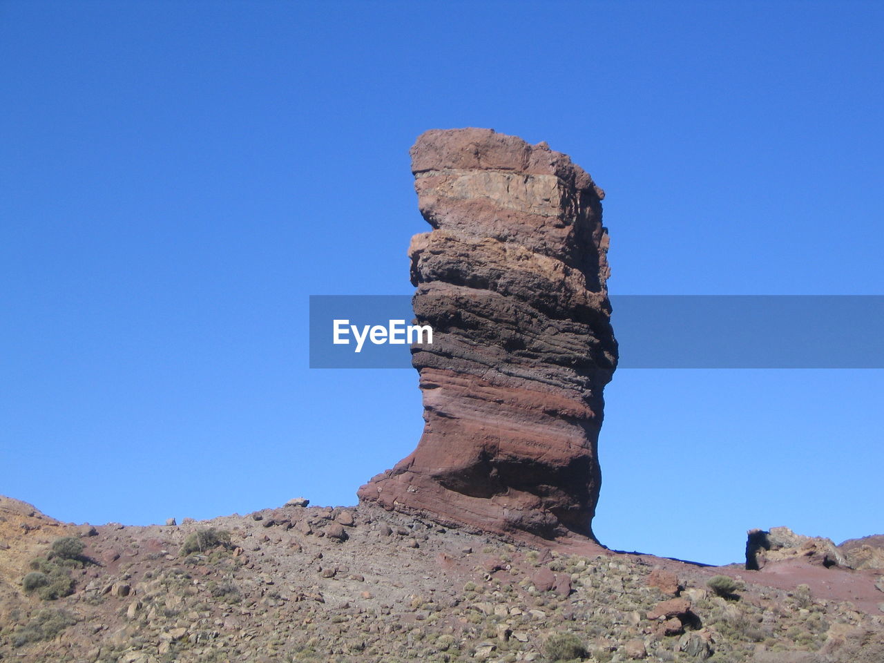 Low angle view of rock formations against clear blue sky