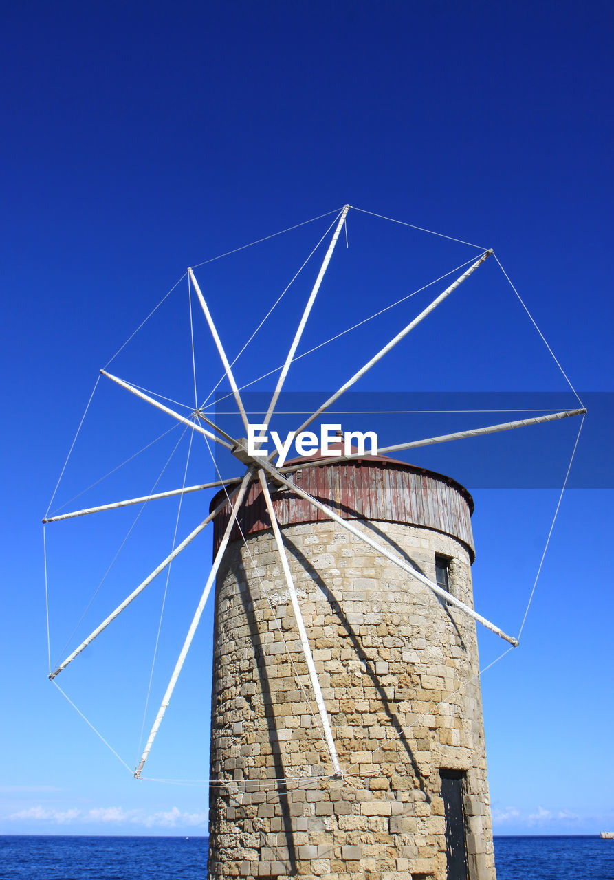 LOW ANGLE VIEW OF TRADITIONAL WINDMILL AGAINST CLEAR BLUE SKY