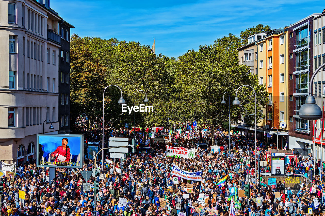 PEOPLE ON STREET AGAINST BUILDINGS