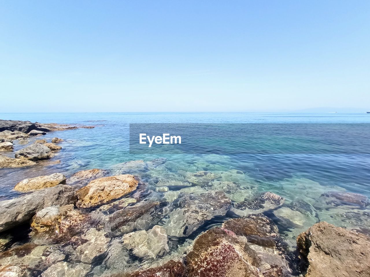water, sea, scenics - nature, sky, beauty in nature, horizon, horizon over water, tranquility, shore, rock, tranquil scene, land, nature, coast, body of water, beach, blue, ocean, clear sky, day, idyllic, no people, cliff, terrain, non-urban scene, outdoors, bay, copy space, cove, sunlight, travel destinations, geology, rock formation, remote, travel, sunny