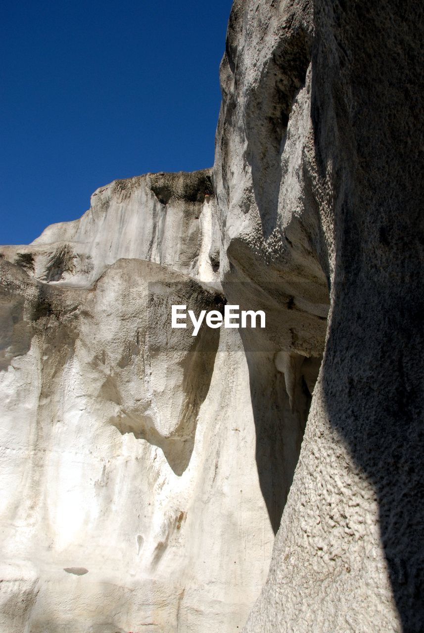 LOW ANGLE VIEW OF ROCK FORMATION AGAINST SKY