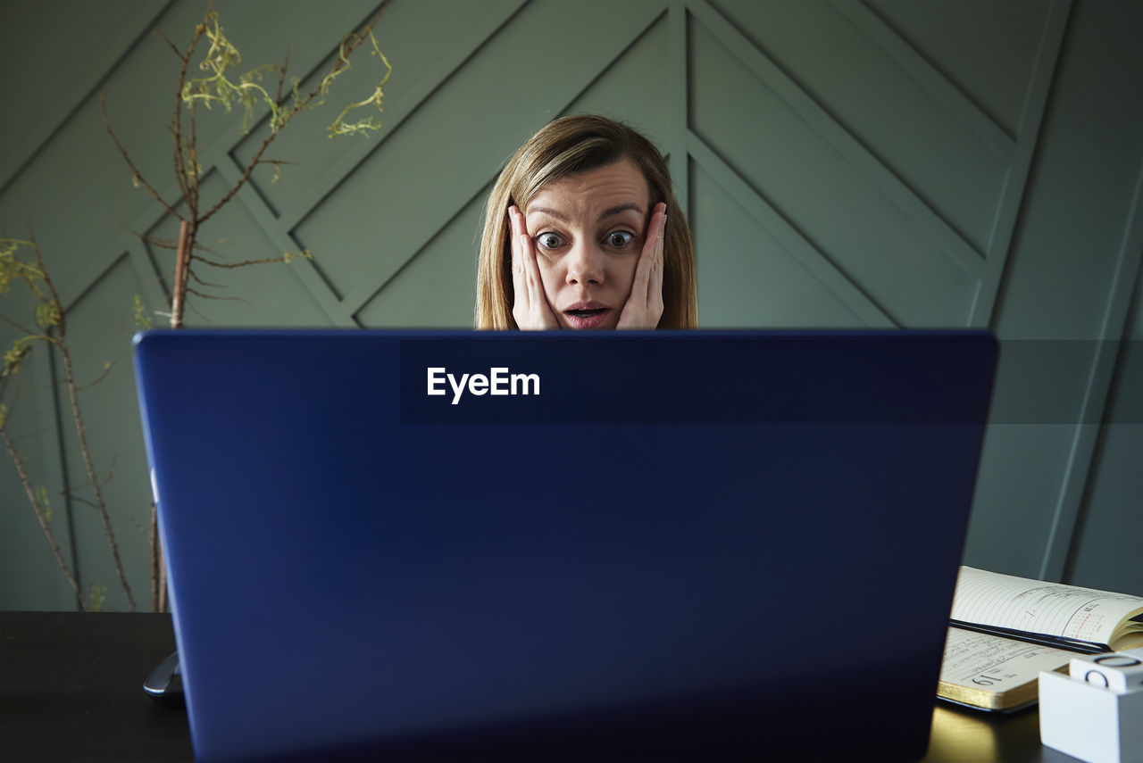 Shocked woman looking at laptop screen