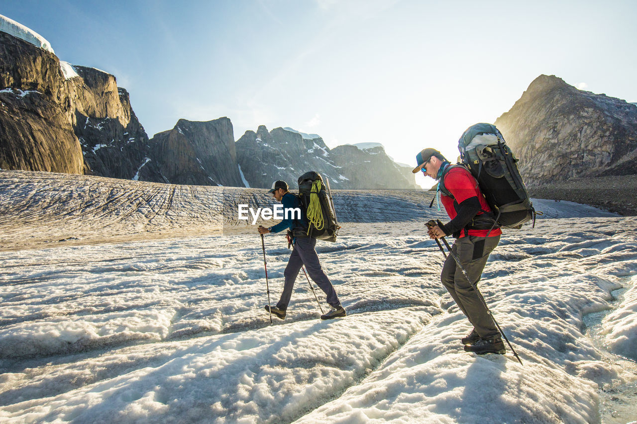 Backpackers hike across glacier on baffin island.