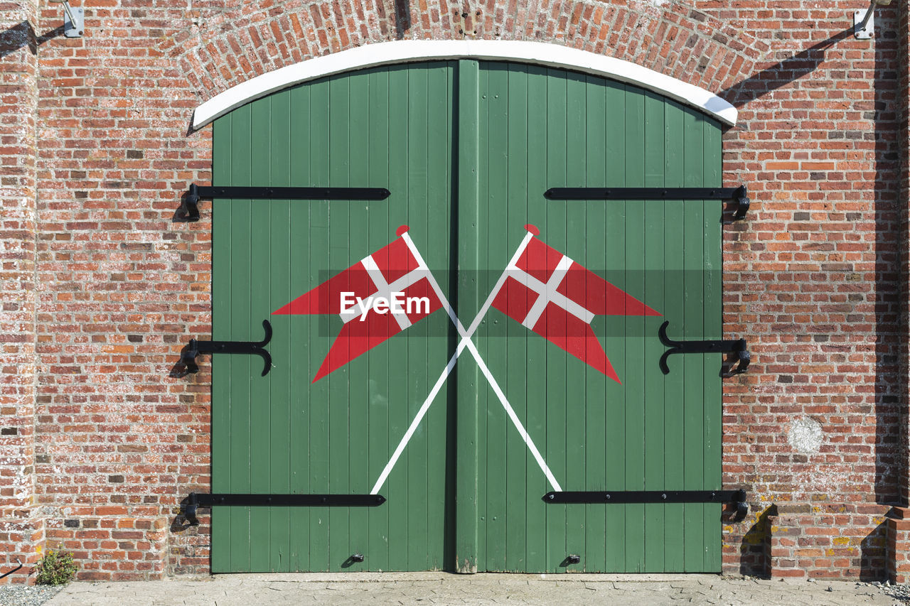 Denmark, romo, danish flags painted on wooden gate of fire station