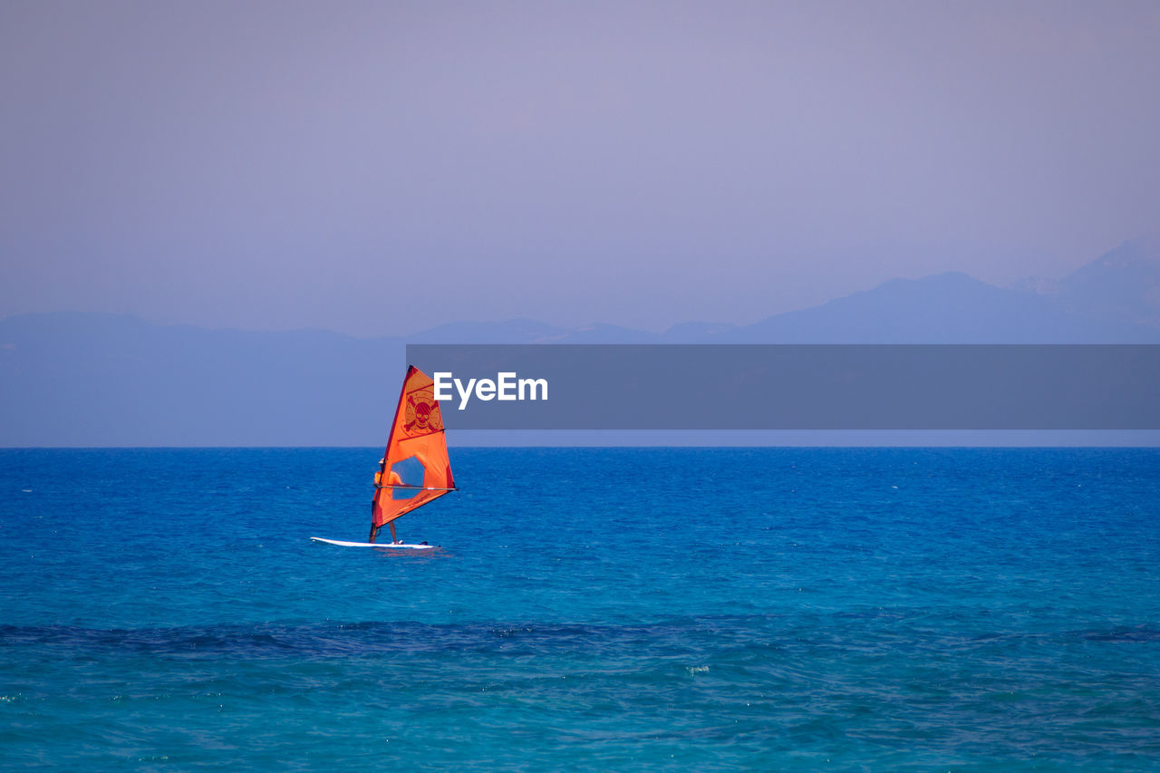 PERSON IN SEA AGAINST CLEAR SKY