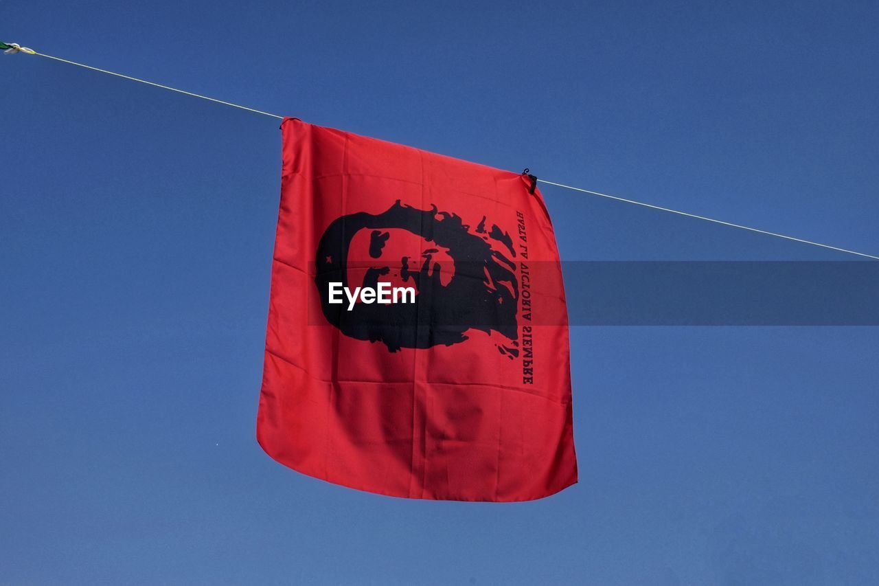 Low angle view of flag on rope against clear blue sky