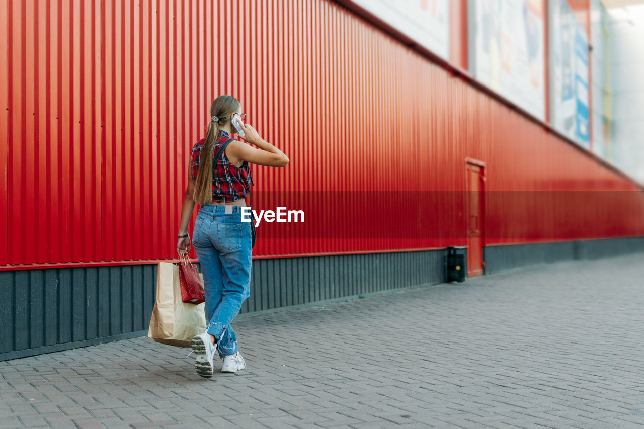 Full length of woman standing on footpath