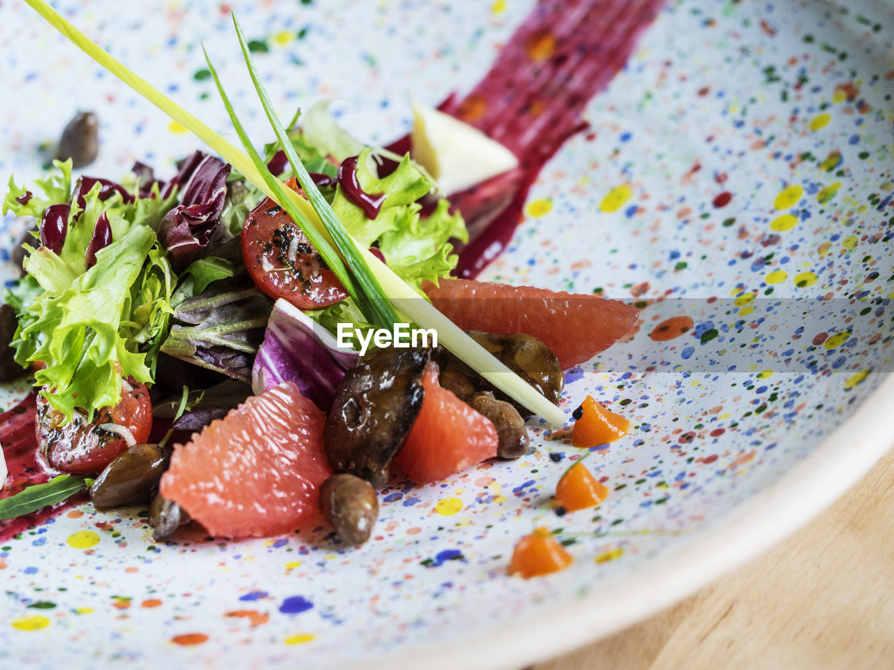 Close-up of salad with quail liver and grapefruit in plate on table