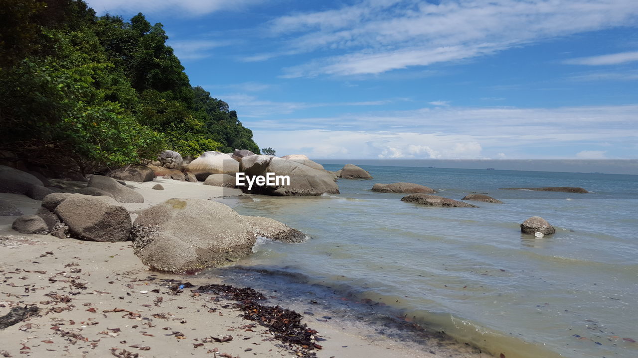 ROCKS ON SHORE AGAINST SKY