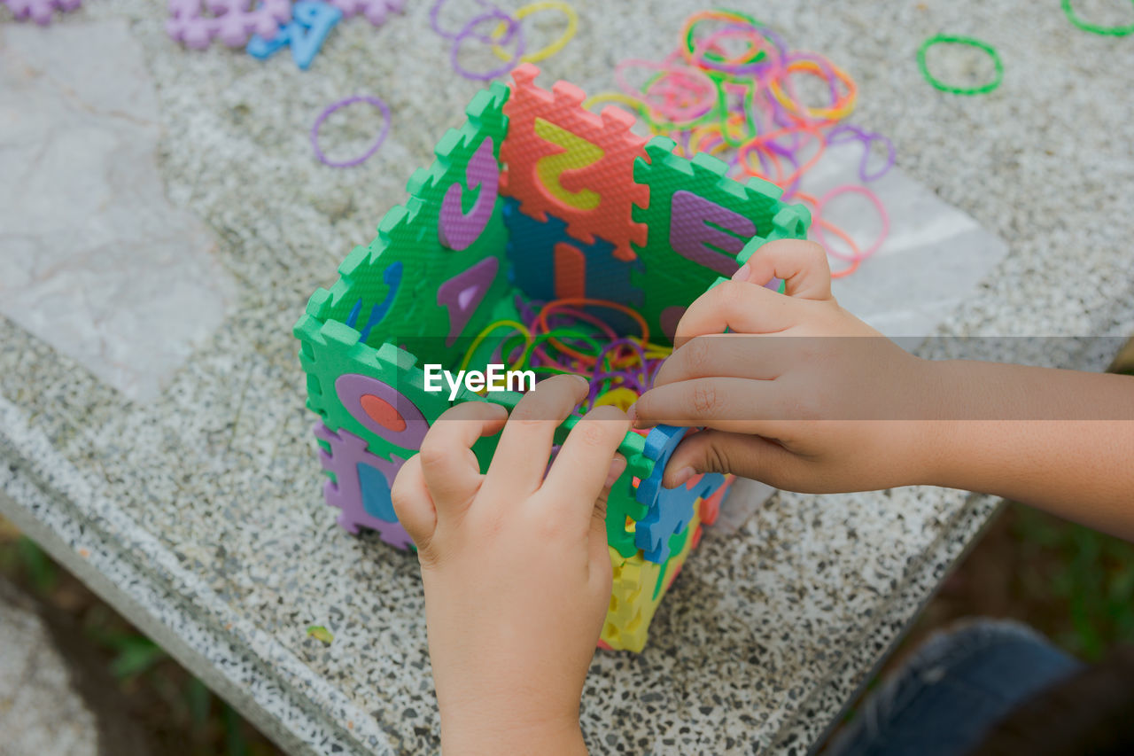 Cropped hands of child playing with toys