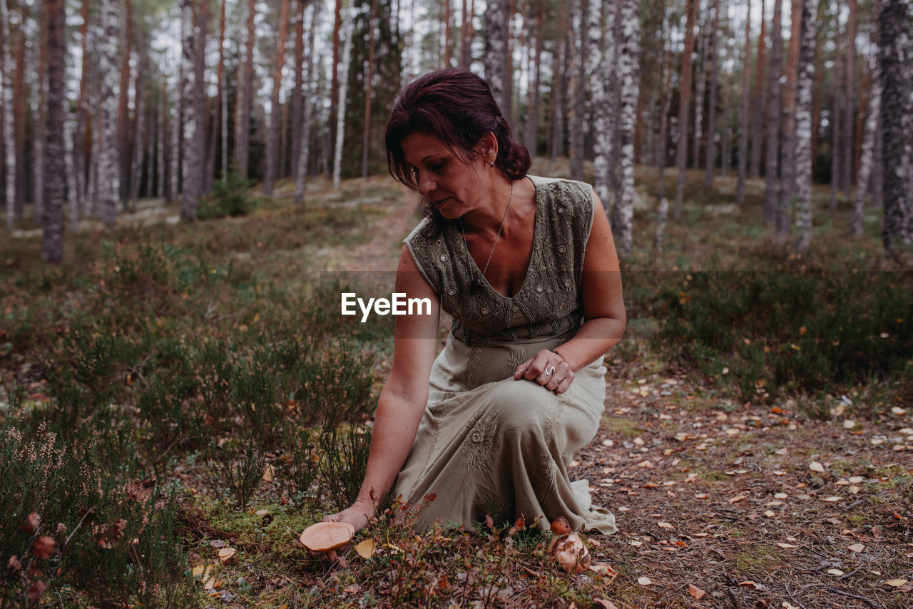 Woman holding wild mushroom in forest
