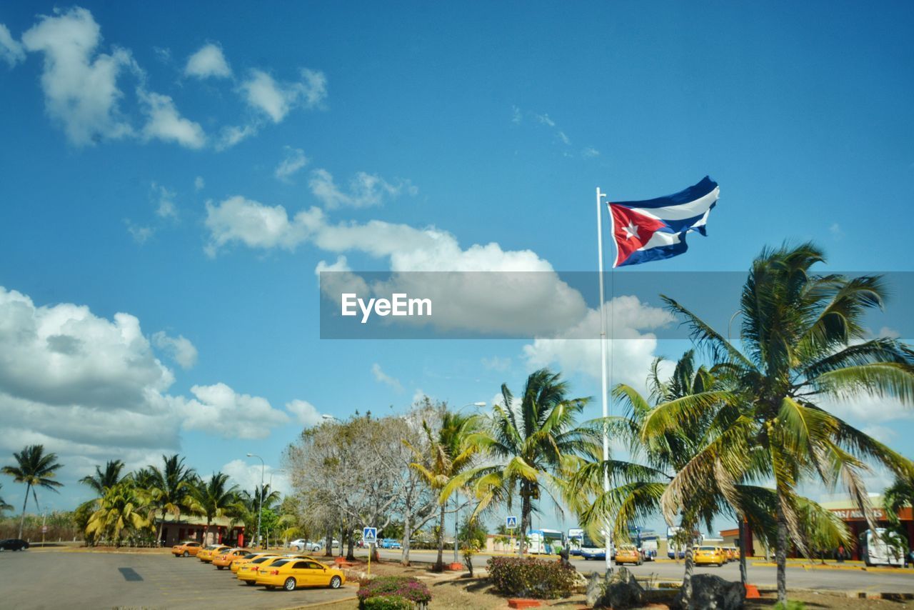 Low angle view of cuban flag fluttering against blue sky