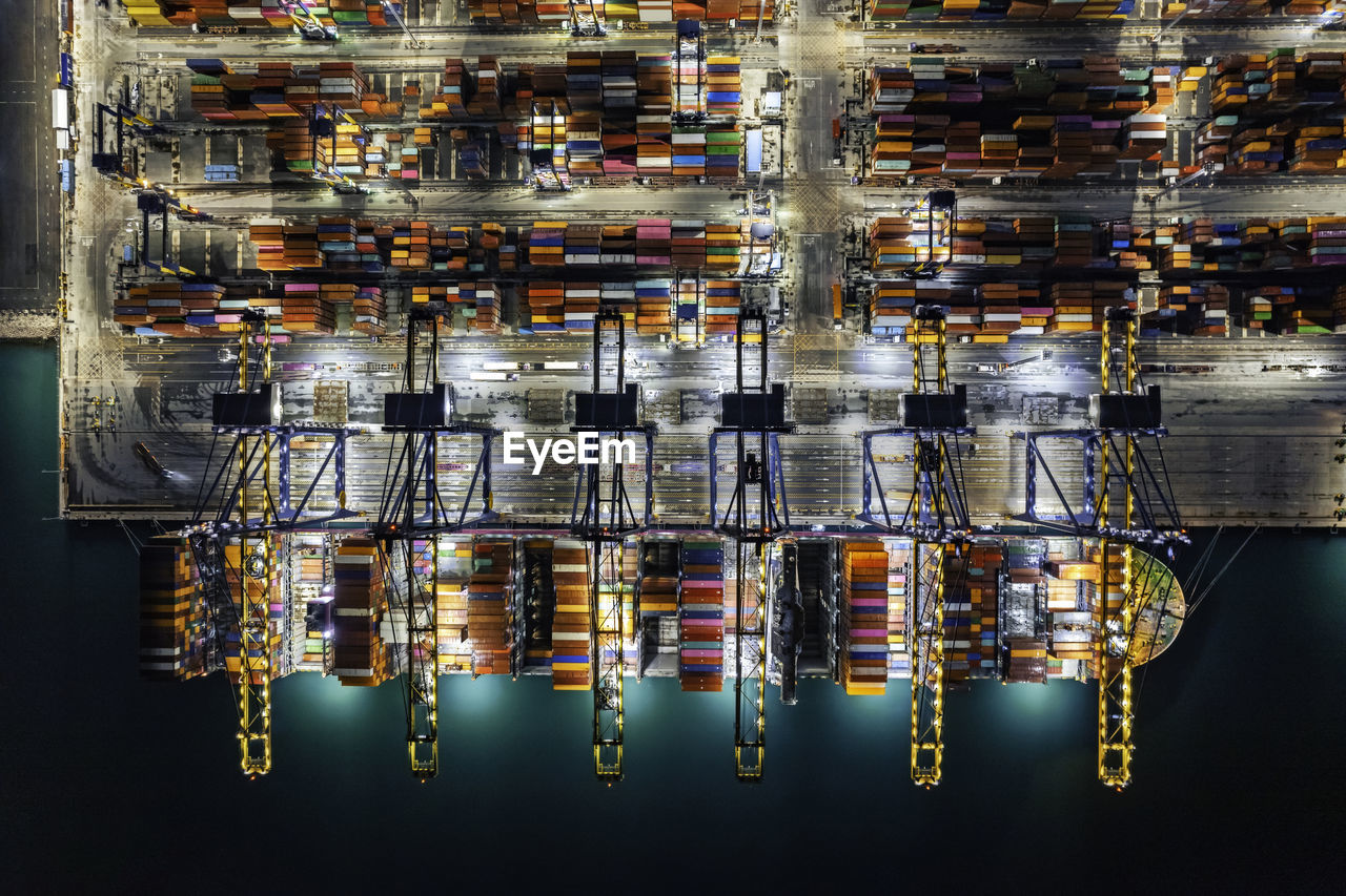 Aerial top view container yard in the harbor area, container ship working at night.