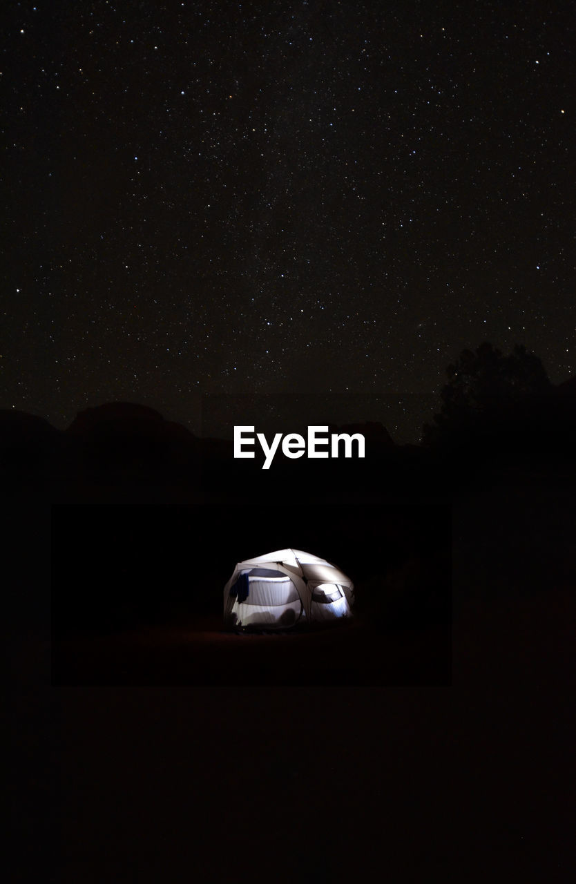 Illuminated tent against sky at night