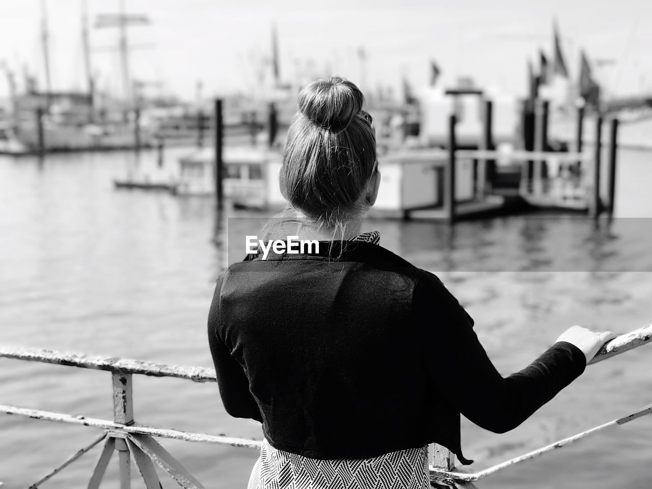 Rear view of woman standing at harbor