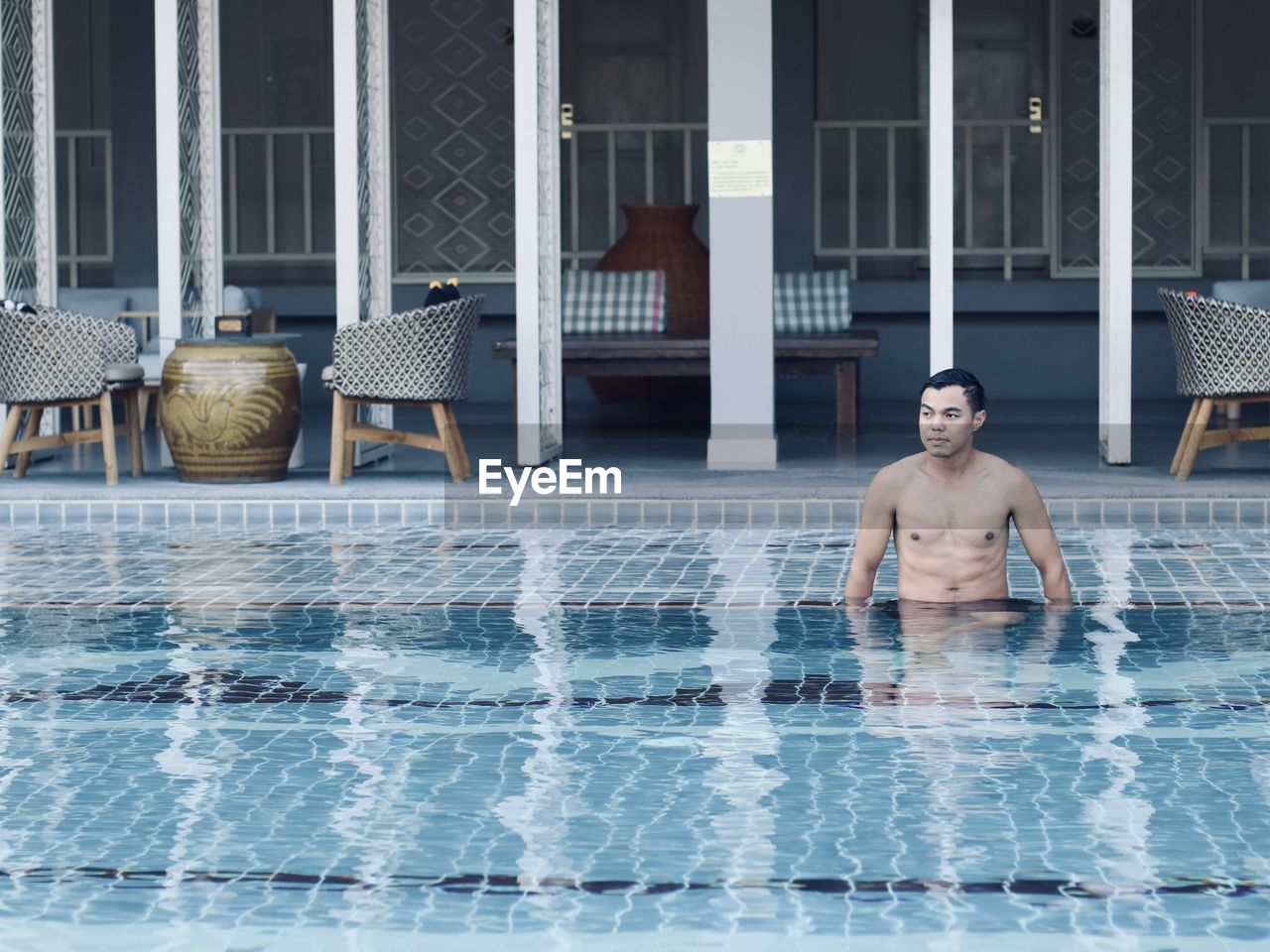 Full length of shirtless man in swimming pool