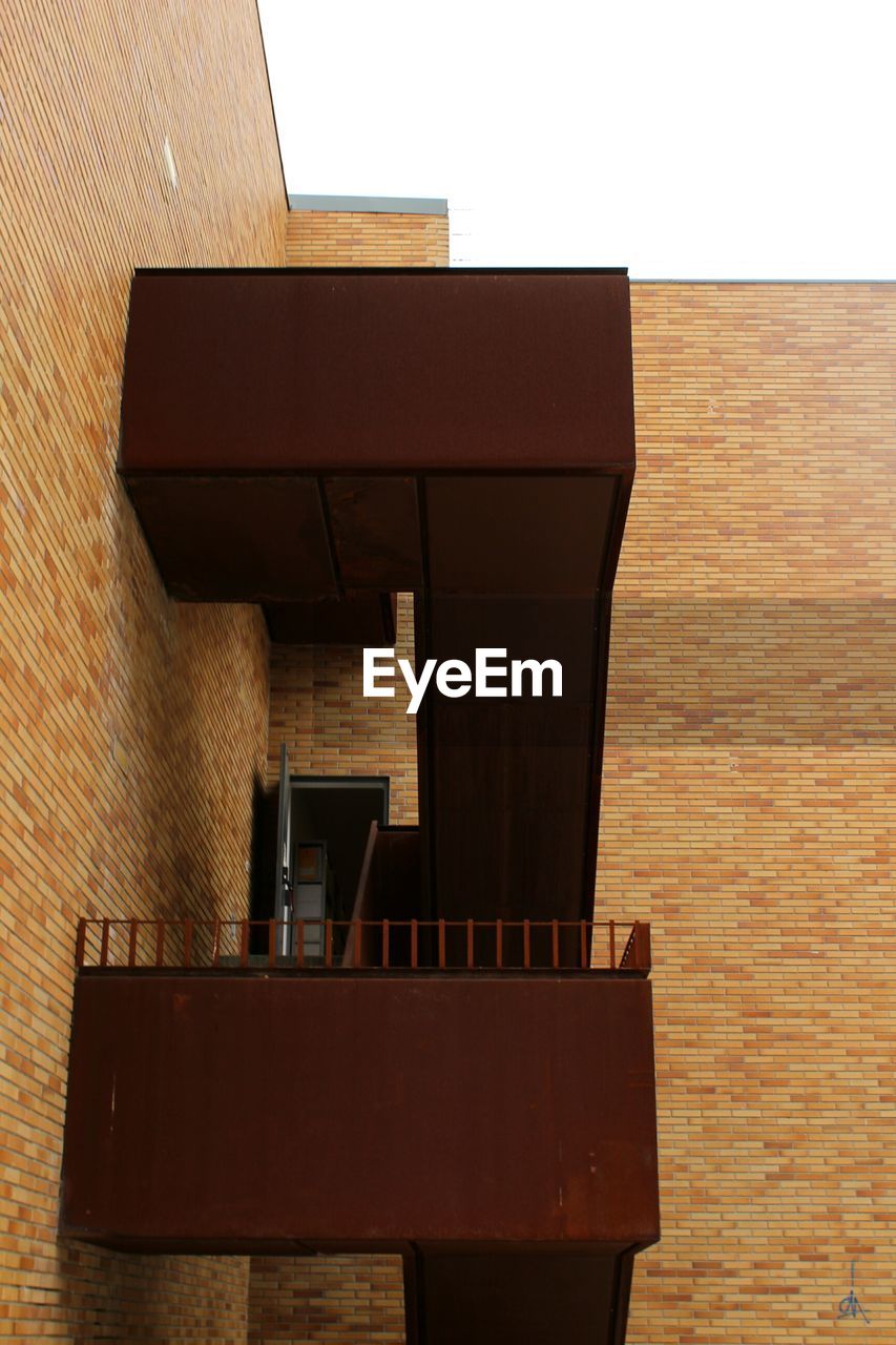 CHAIR AND TABLE AGAINST BRICK WALL