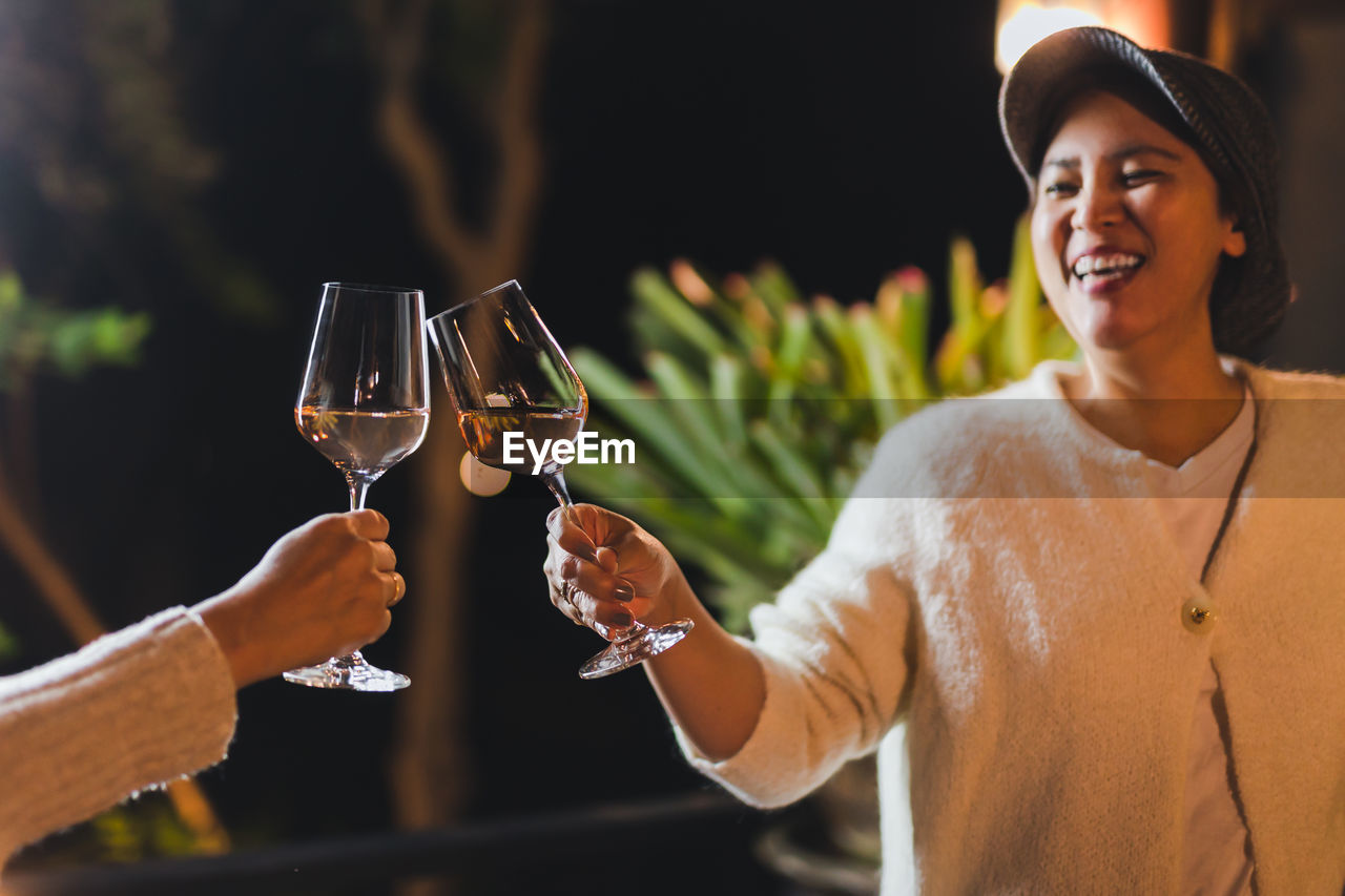 Happy smiling woman hand clicking glasses of wine celebration concept.