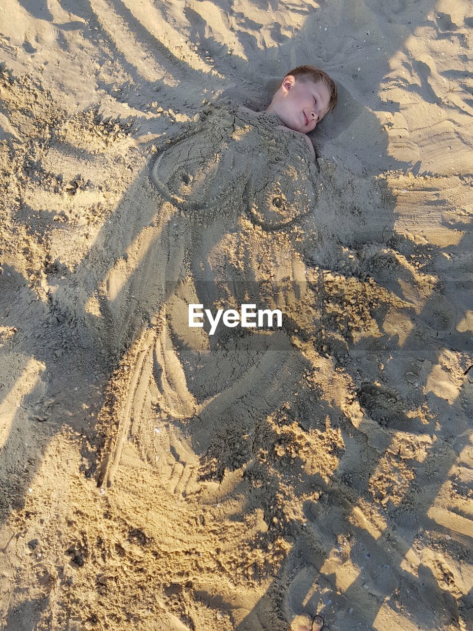 HIGH ANGLE VIEW OF BOY ON SAND