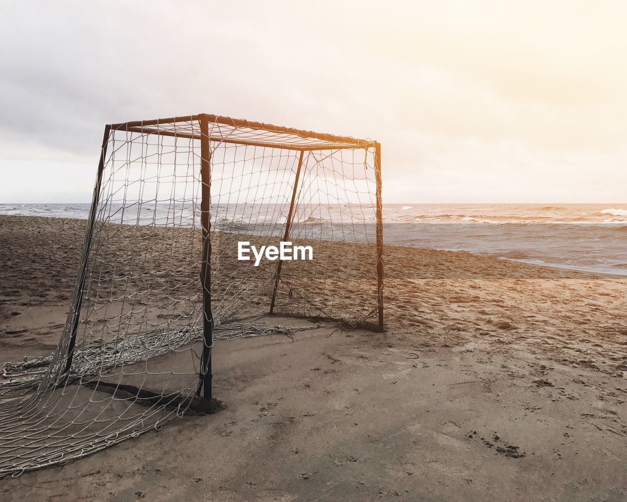 Abandoned net on beach against sky during sunset