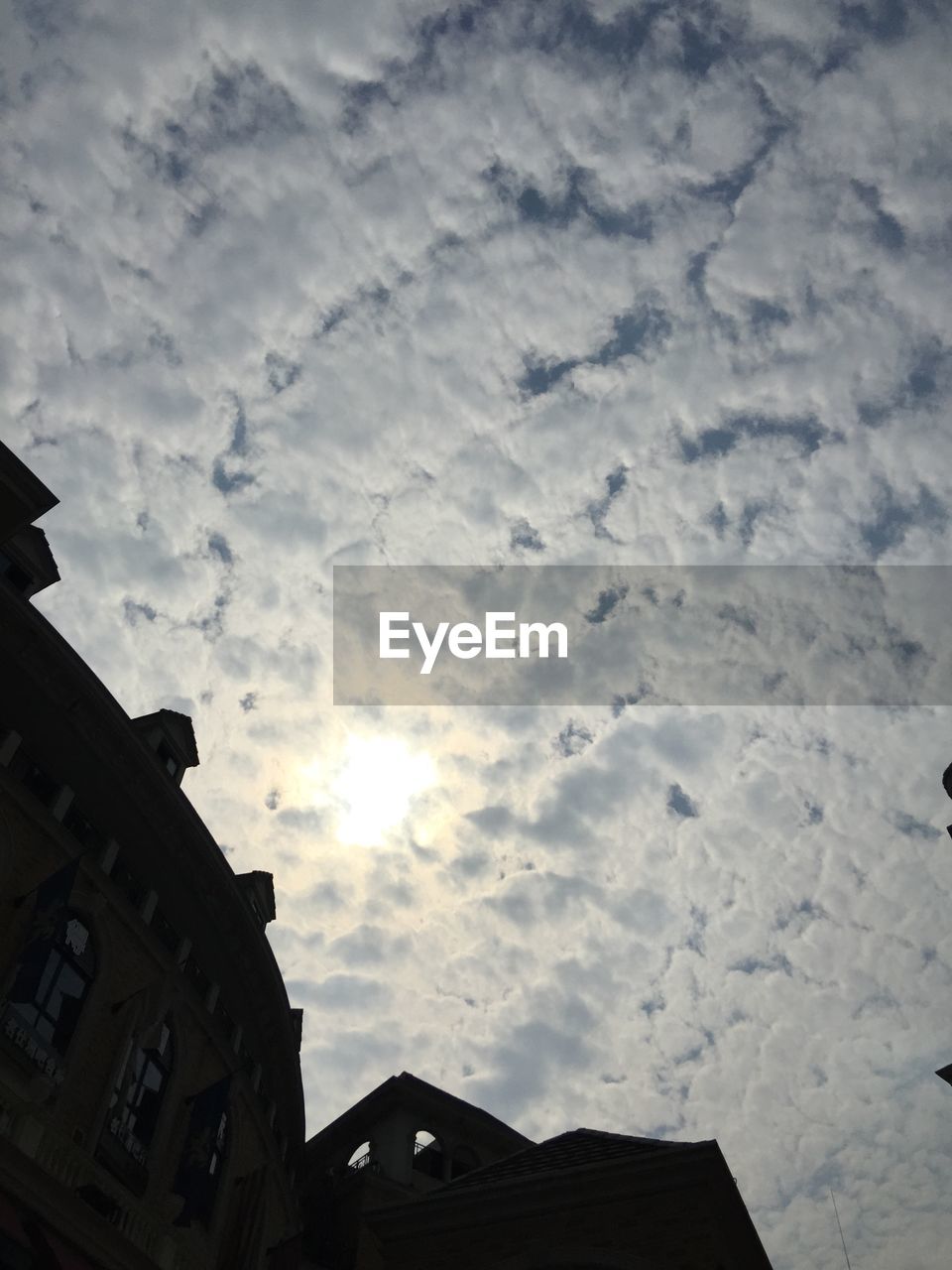 LOW ANGLE VIEW OF BUILDINGS AGAINST CLOUDY SKY