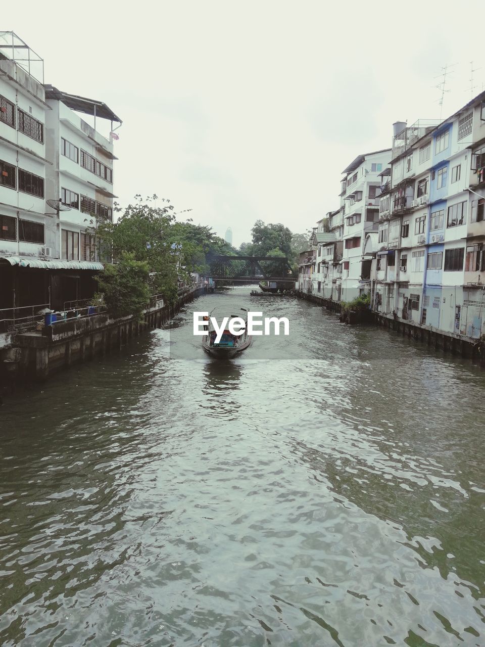 CANAL AMIDST BUILDINGS AGAINST SKY