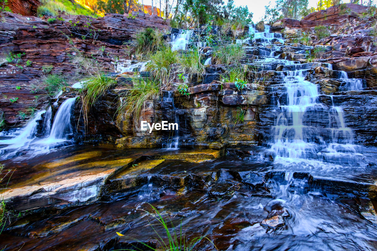 VIEW OF WATERFALL WITH ROCKS IN RIVER