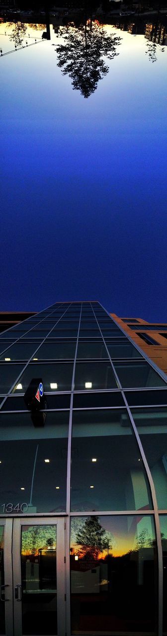LOW ANGLE VIEW OF ILLUMINATED BUILT STRUCTURES AGAINST BLUE SKY