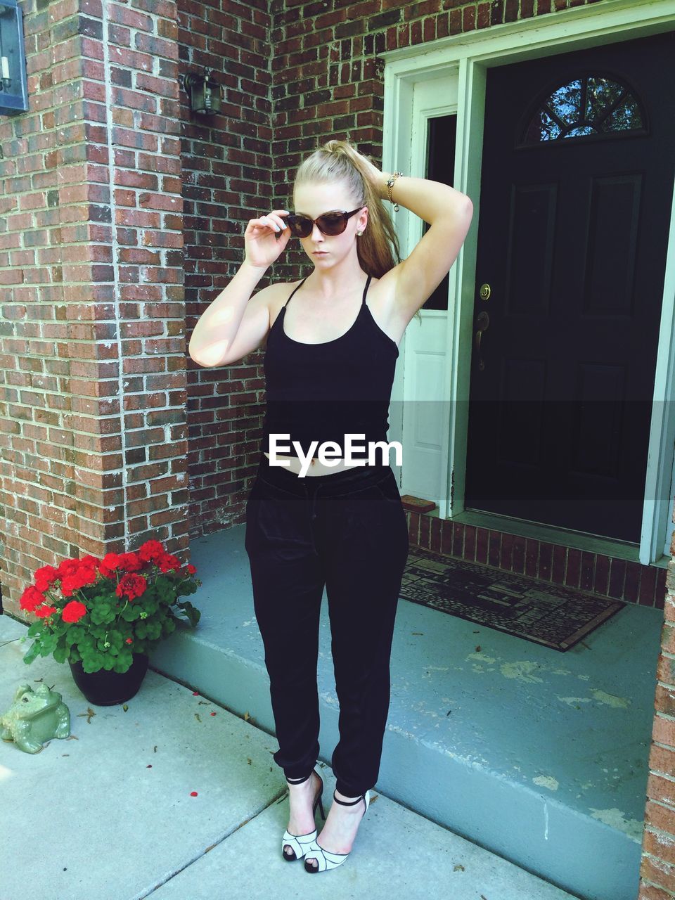 Young woman standing outside house