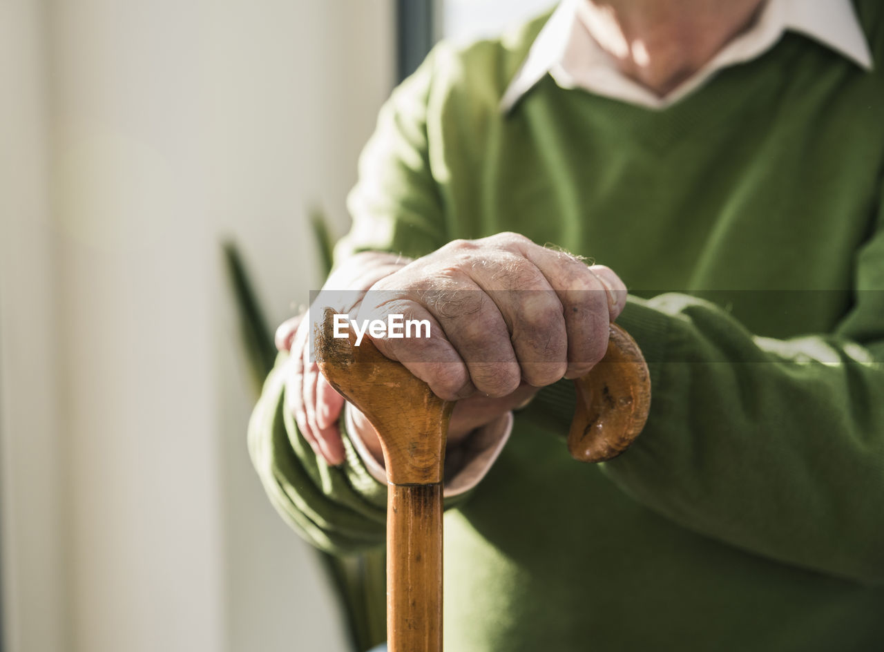 Close-up of senior man leaning on cane