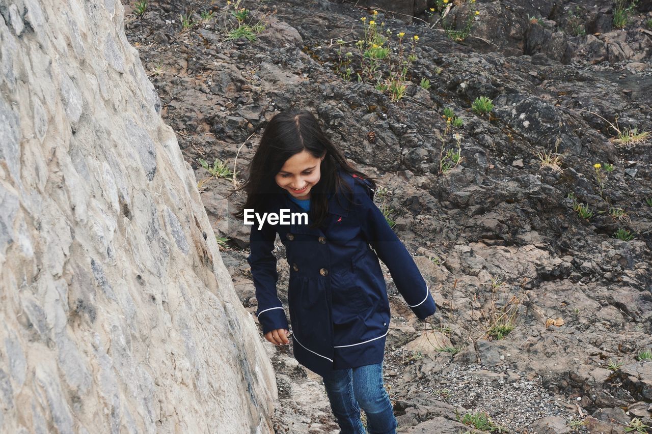 High angle view of smiling girl walking on rock formations