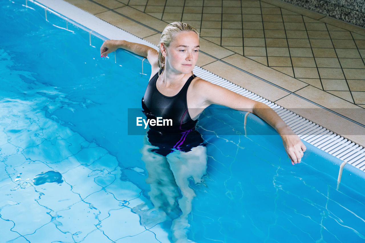 High angle view of woman standing in swimming pool