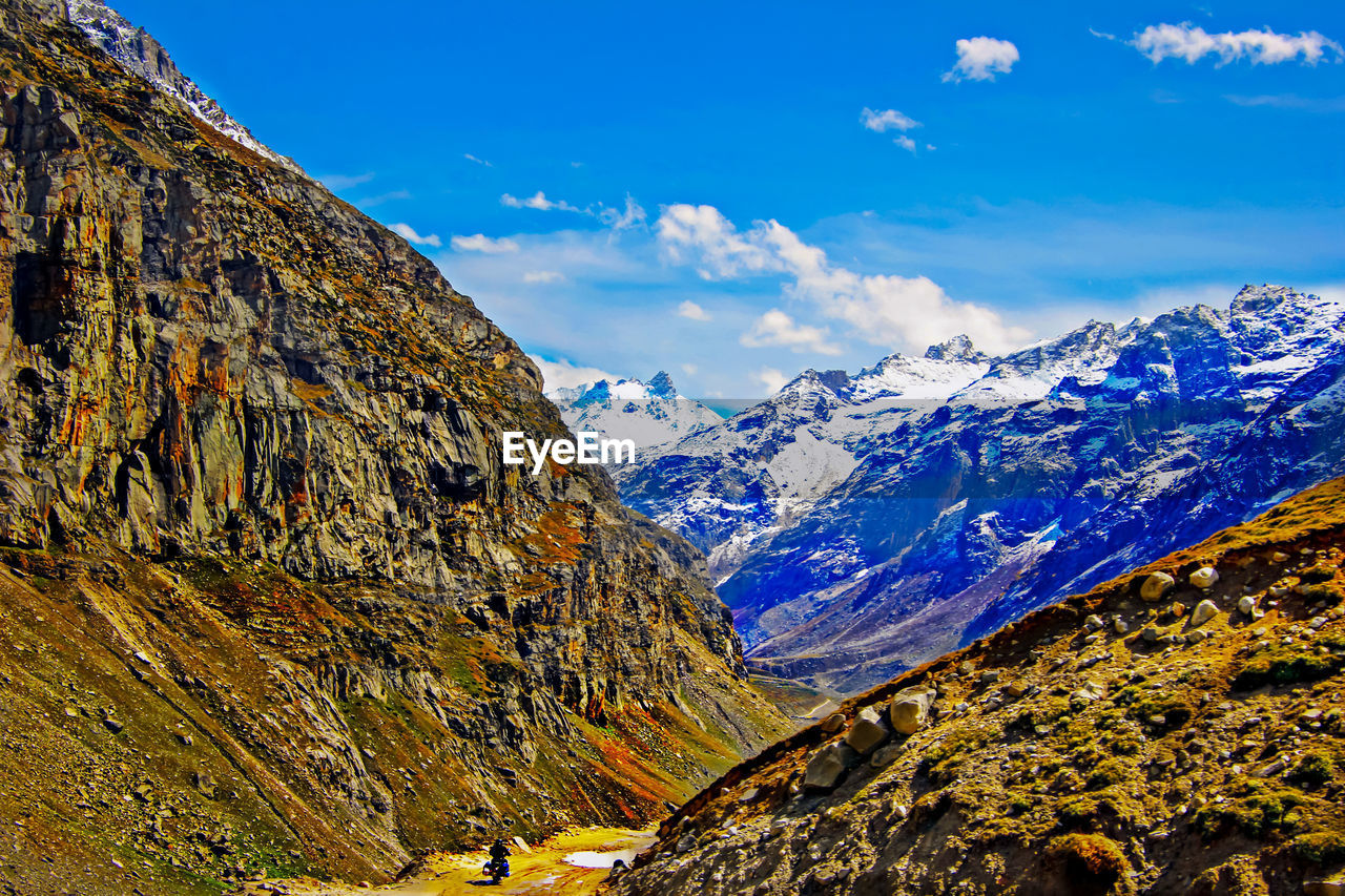 Scenic view of snowcapped mountains against blue sky