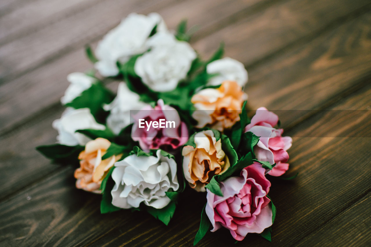 HIGH ANGLE VIEW OF ROSE BOUQUET ON WHITE TABLE