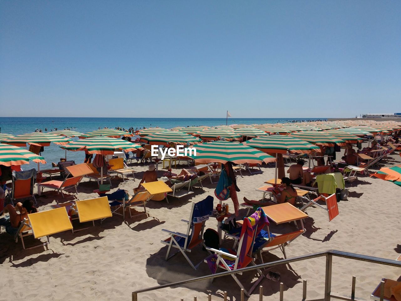 PANORAMIC VIEW OF PEOPLE ON BEACH AGAINST CLEAR SKY