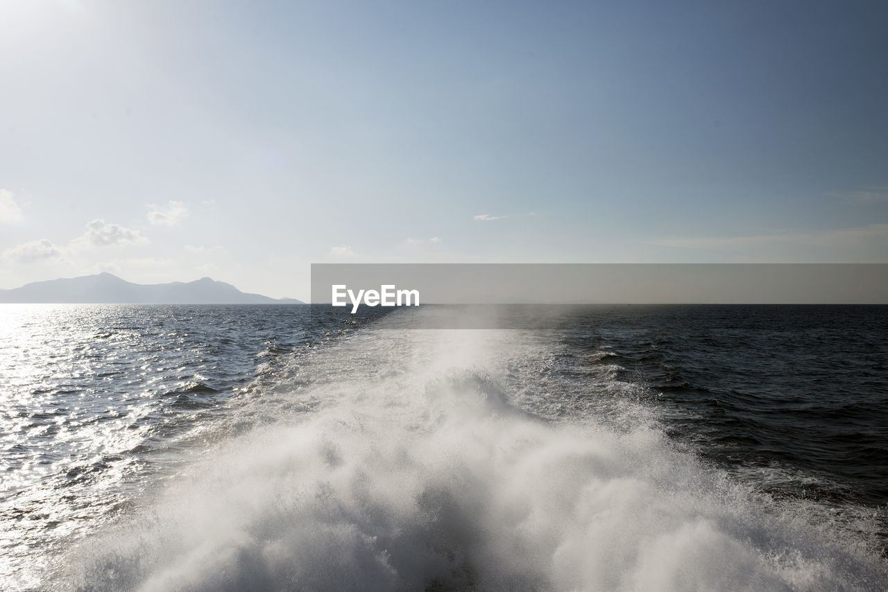 A view of a horizon, seascape, waves and splash caused by catamaran in the aegean sea in summer time