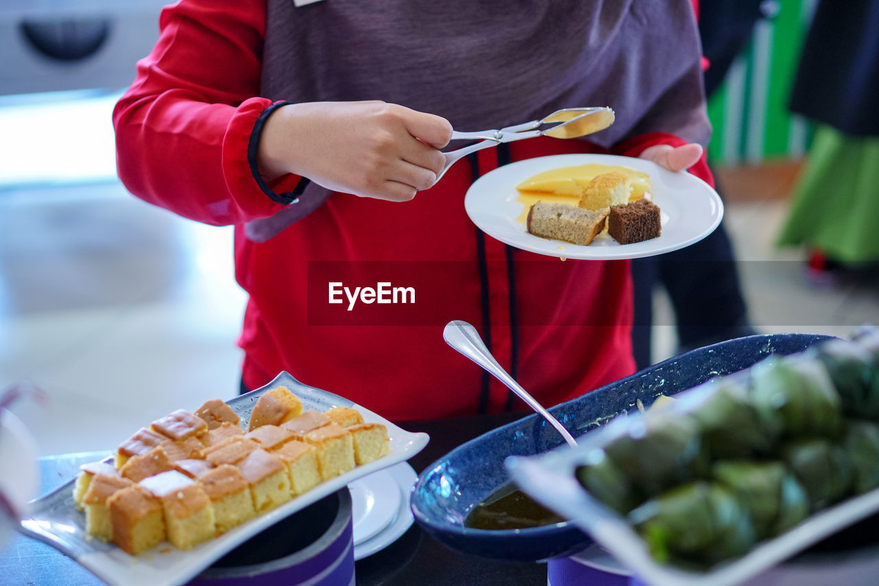 Midsection of woman having food in plate