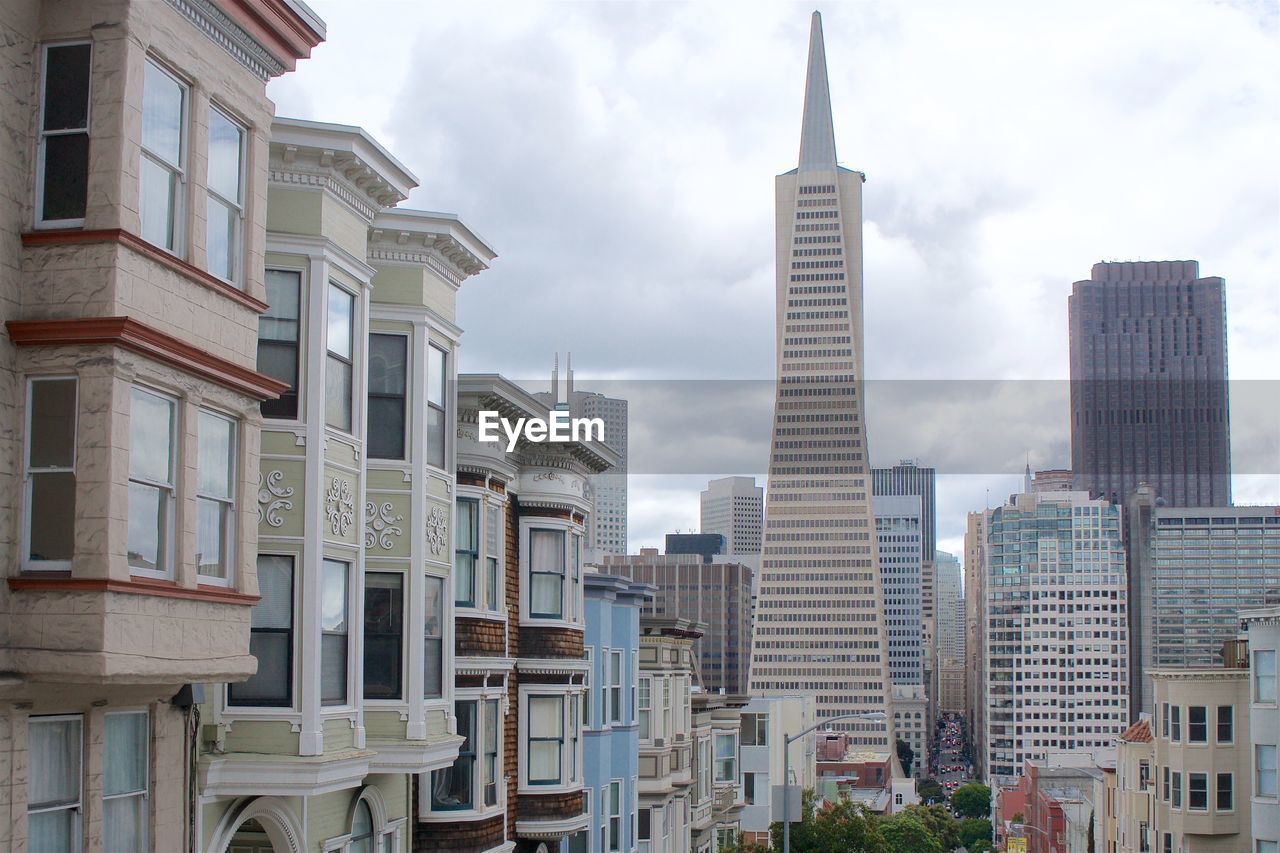 LOW ANGLE VIEW OF BUILDINGS AGAINST CLOUDY SKY