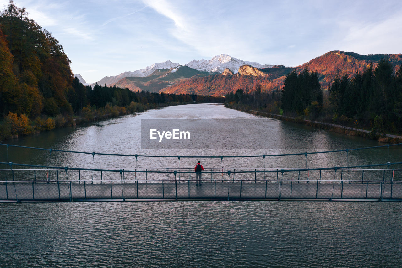 Aerial view of man standing on bridge over salzach river at sunset, salzburg, austria.