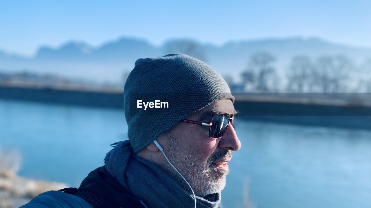 Close-up of man wearing sunglasses and knit hat standing outdoors during winter